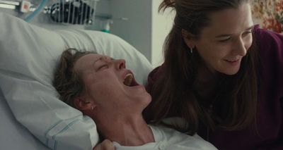 a woman laying in a hospital bed next to a woman