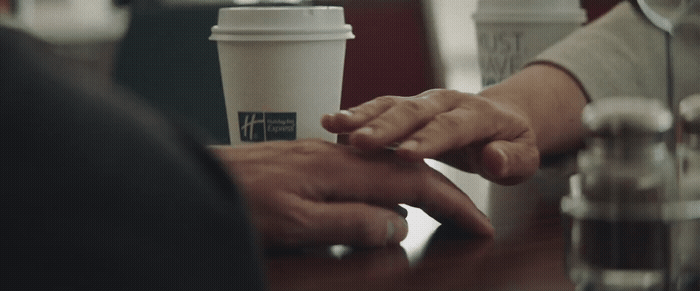 a couple of people holding hands over a table