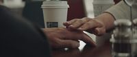 a couple of people holding hands over a table