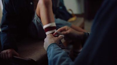 a person sitting on a couch holding a cigarette