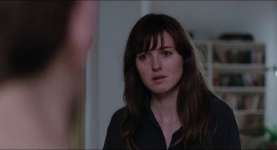 a woman standing in front of a man in a living room
