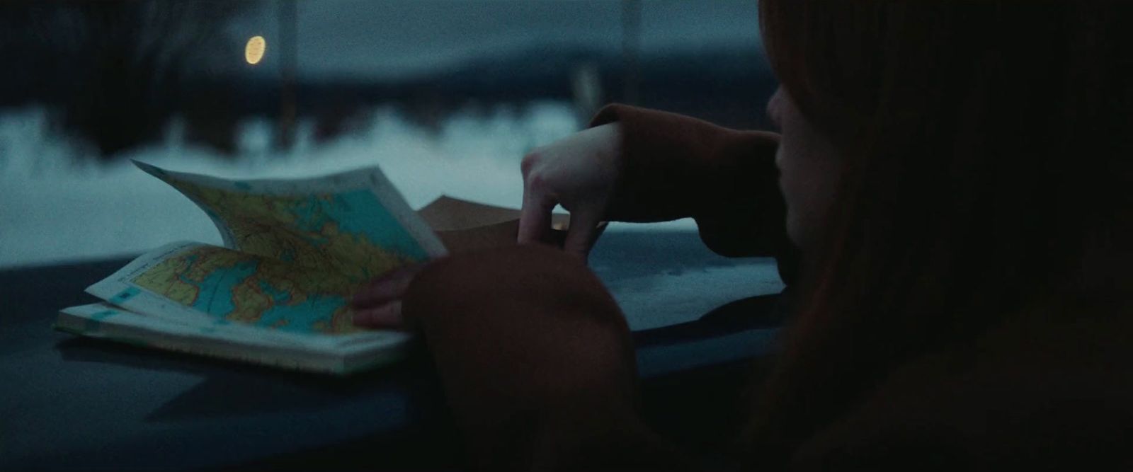 a woman looking at a map while sitting at a table