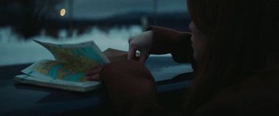 a woman looking at a map while sitting at a table