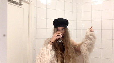 a woman standing in a bathroom brushing her long hair