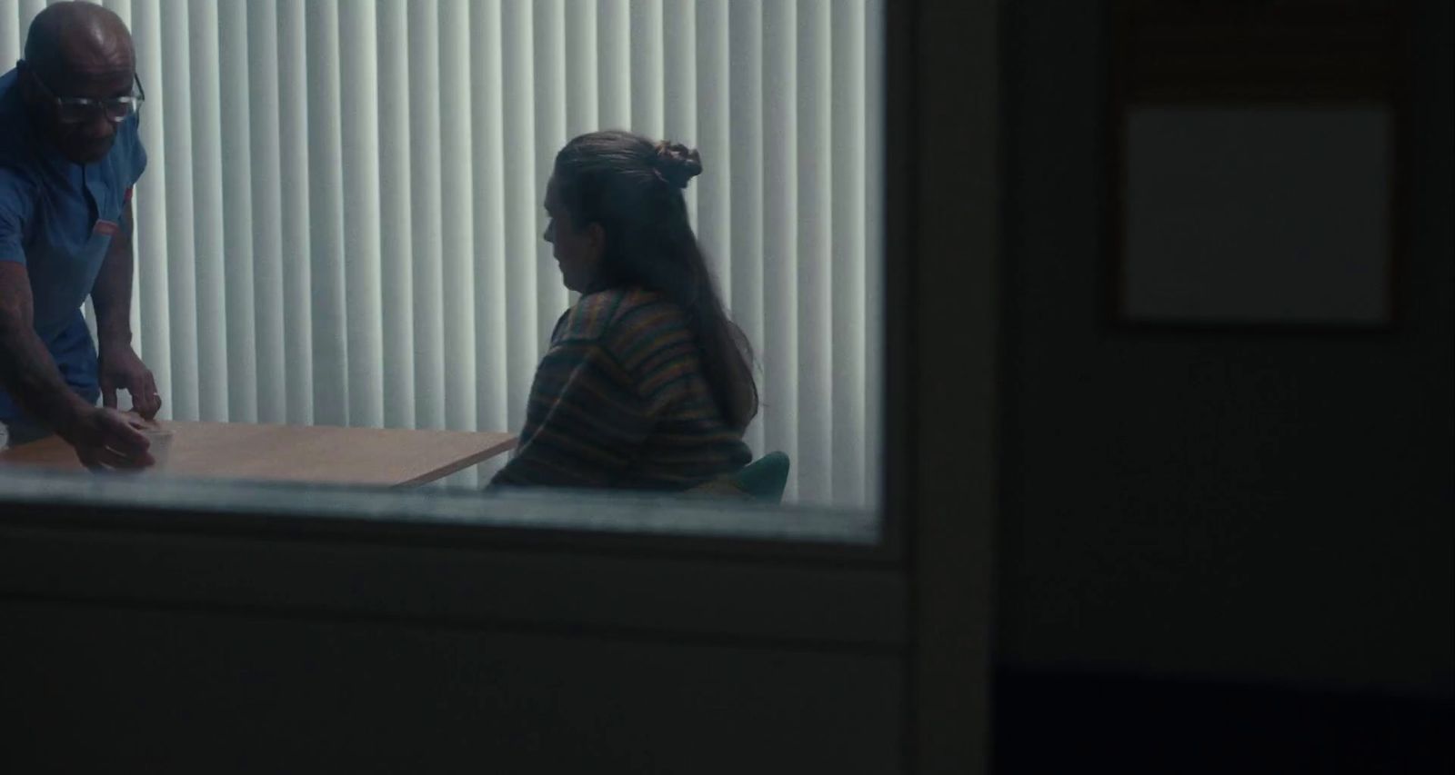 a man standing next to a woman sitting at a table