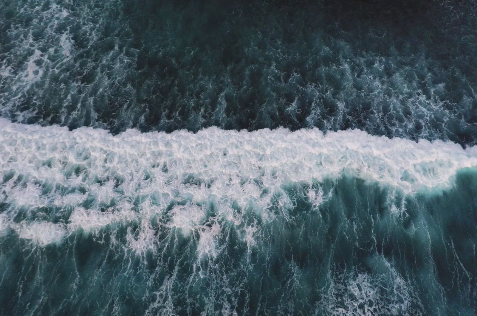 an aerial view of the ocean with waves