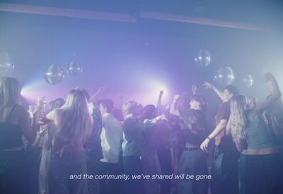 a group of people standing around a disco ball