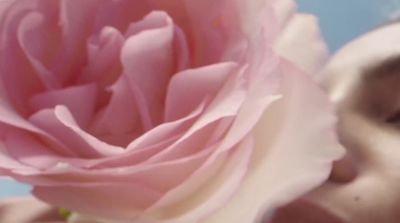 a close up of a person kissing a flower