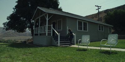 a woman is standing outside of a house