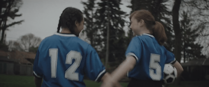 a couple of women standing next to each other holding hands