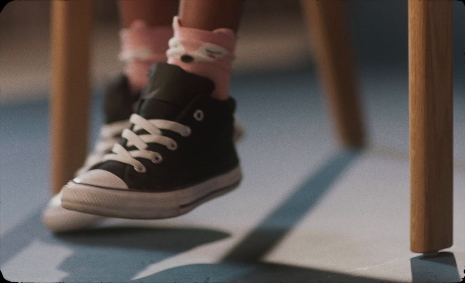 a close up of a person's feet wearing black and white sneakers