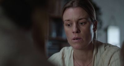 a woman in a white shirt is looking at something