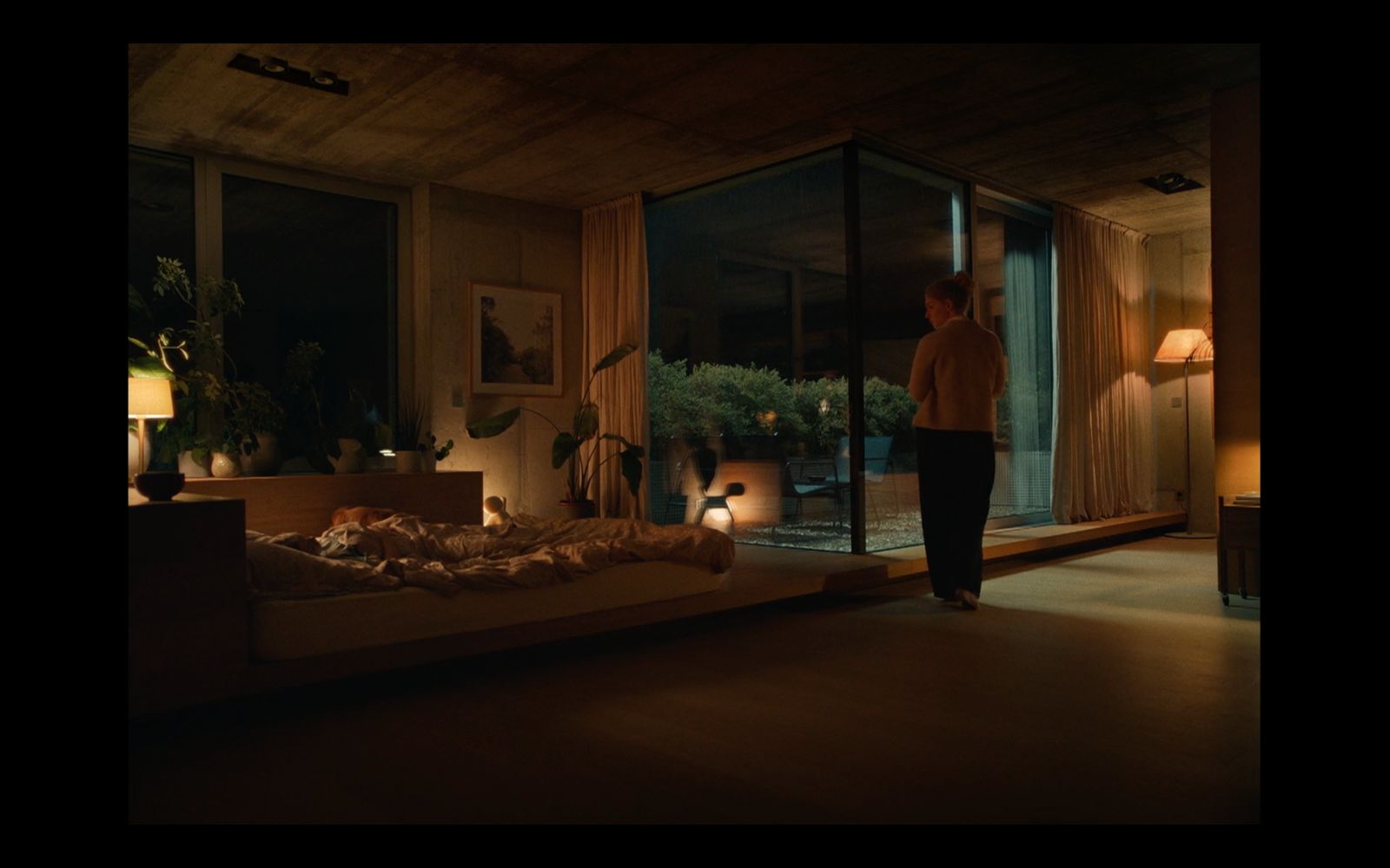 a man standing in front of a bed in a room