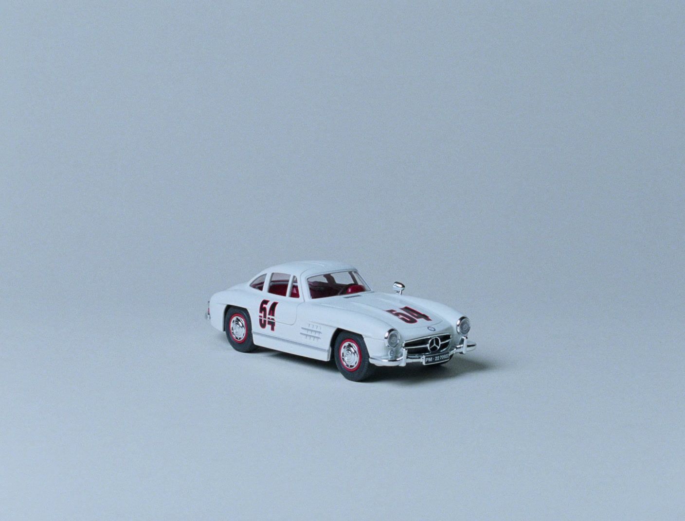 a white toy car with a red stripe on it