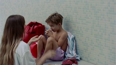 a boy and a girl sitting on the floor next to each other