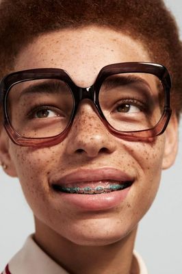 a young man with freckled hair wearing glasses