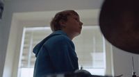 a woman standing in a kitchen next to a window
