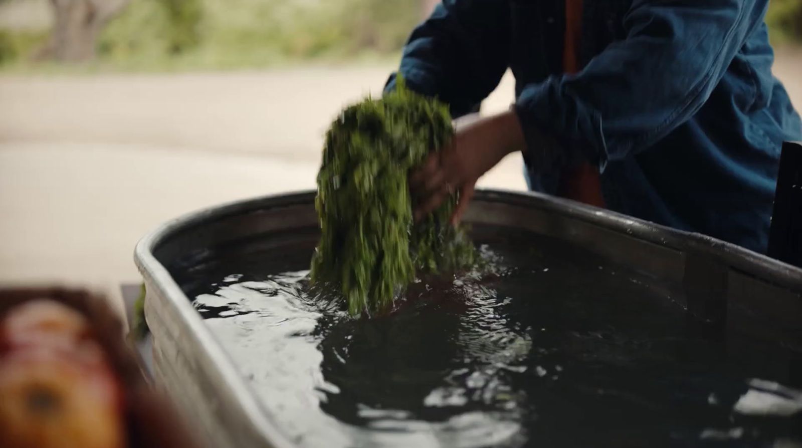 a person is cleaning a large metal barrel of water