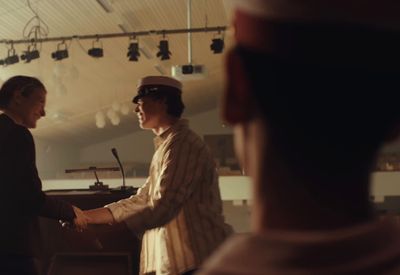 a man shaking another mans hand in a room