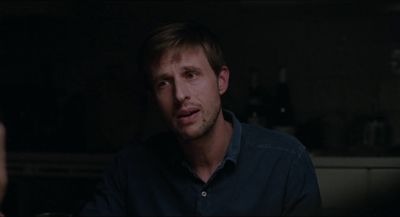 a man in a dark room looking at the camera
