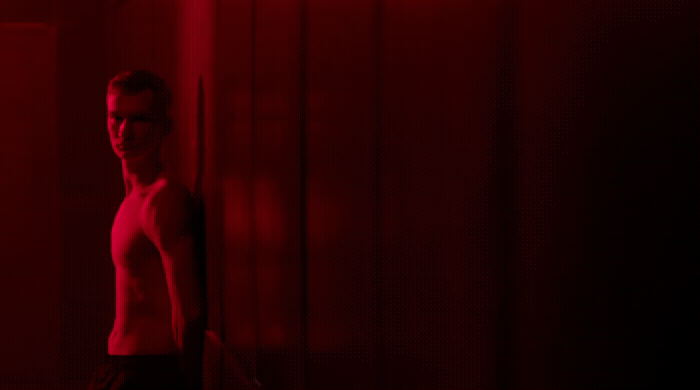 a man standing in front of a red light
