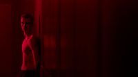 a man standing in front of a red light