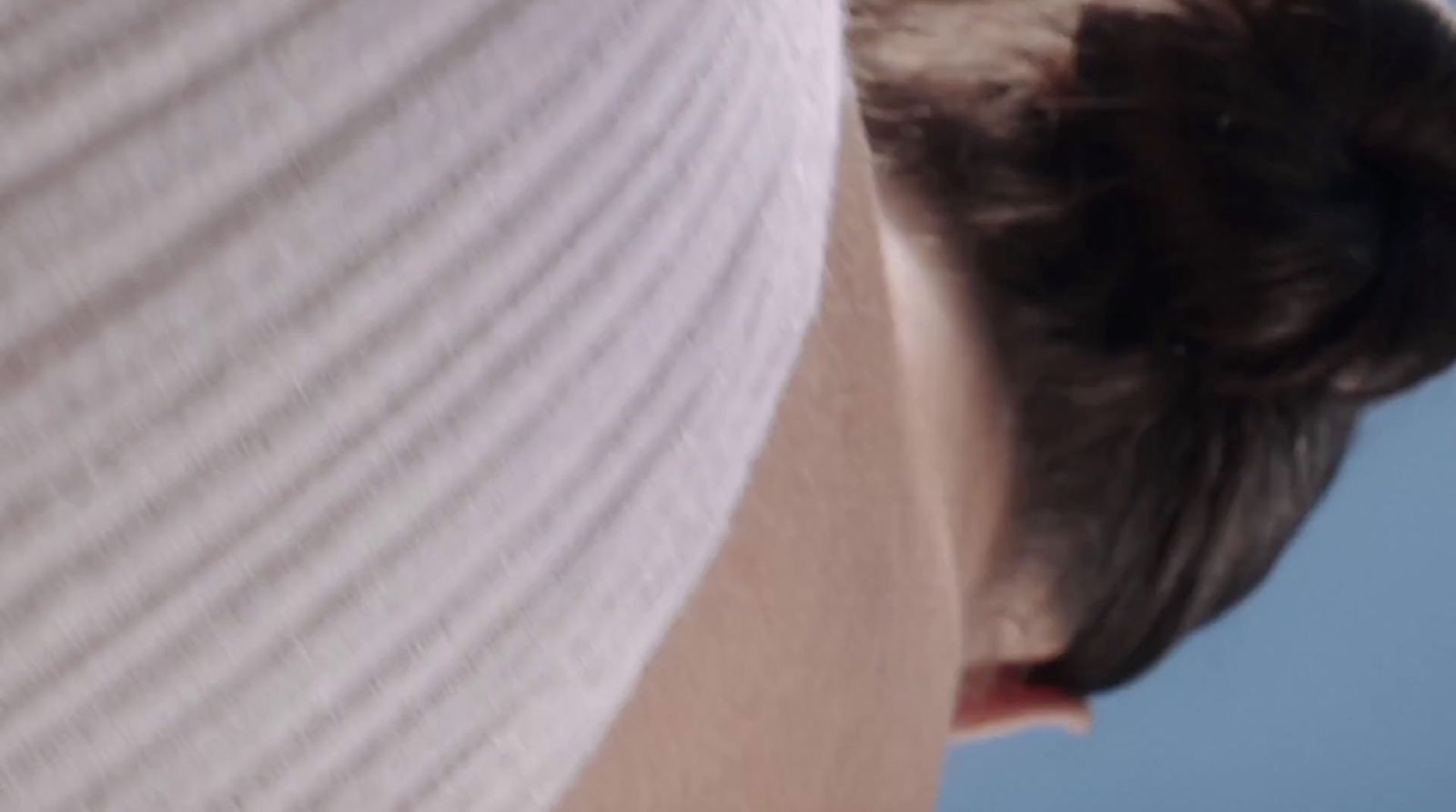 a close up of a person's head with a blue sky in the background