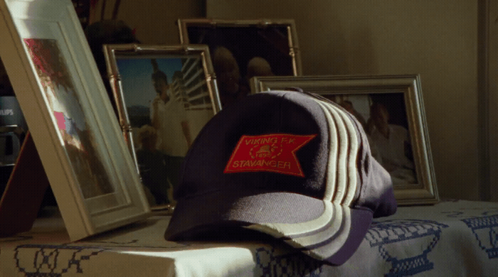 a hat sitting on top of a table next to pictures
