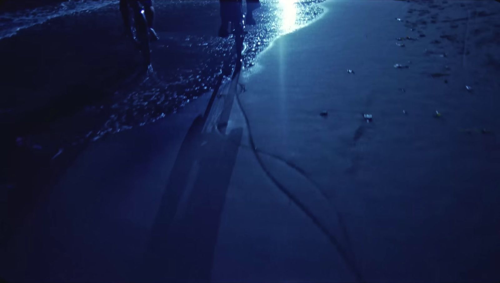 a couple of people standing on a beach next to the ocean