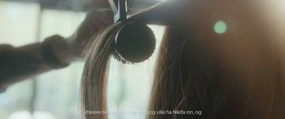 a woman is blow drying her long hair