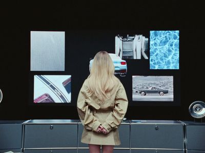 a woman standing in front of a display of cars