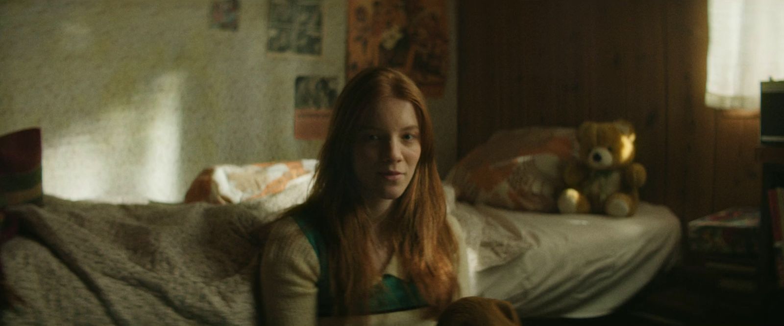 a woman sitting on a bed with a teddy bear