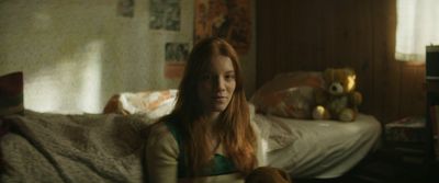 a woman sitting on a bed with a teddy bear