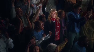 a woman wearing a red scarf standing in front of a crowd of people