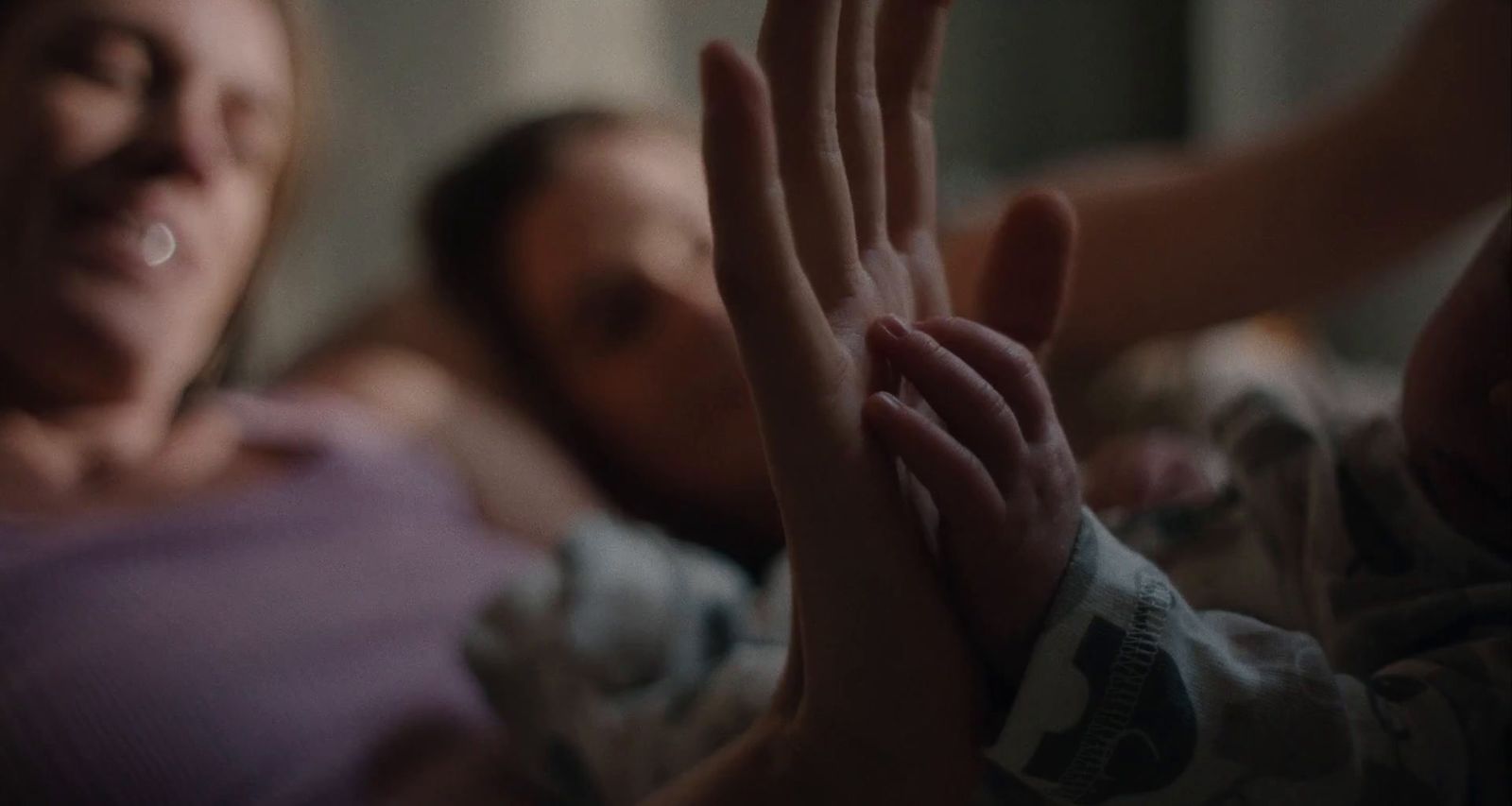 a woman laying in bed with a baby in her arms