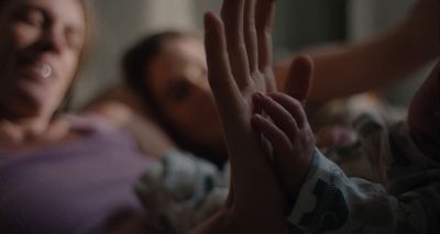 a woman laying in bed with a baby in her arms
