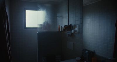 a dark bathroom with a window and a sink