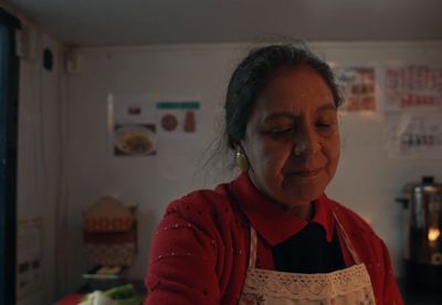 a woman in a red shirt is preparing food in a kitchen