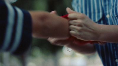 a close up of two people holding hands