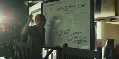 a woman standing in front of a whiteboard with writing on it