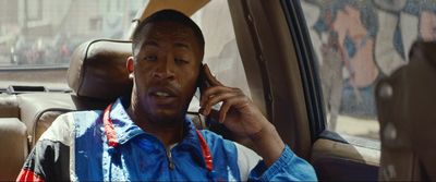 a man sitting in a car talking on a cell phone