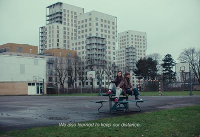 a couple of people sitting on top of a bench