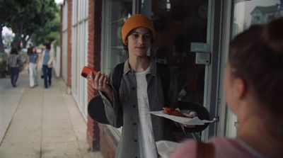 a woman holding a plate of food in front of a store