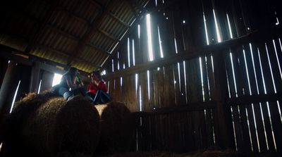 a couple of people sitting on top of hay bales