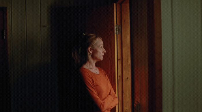 a woman standing in a doorway with her hands on her hips