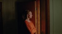 a woman standing in a doorway with her hands on her hips