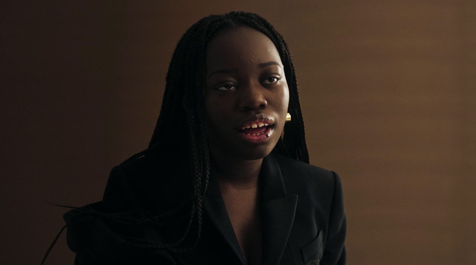 a woman with dreadlocks wearing a black suit