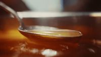 a spoon full of liquid sitting on top of a table