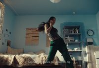 a woman standing on a bed in a room