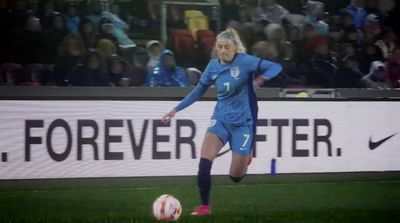 a woman kicking a soccer ball on a field